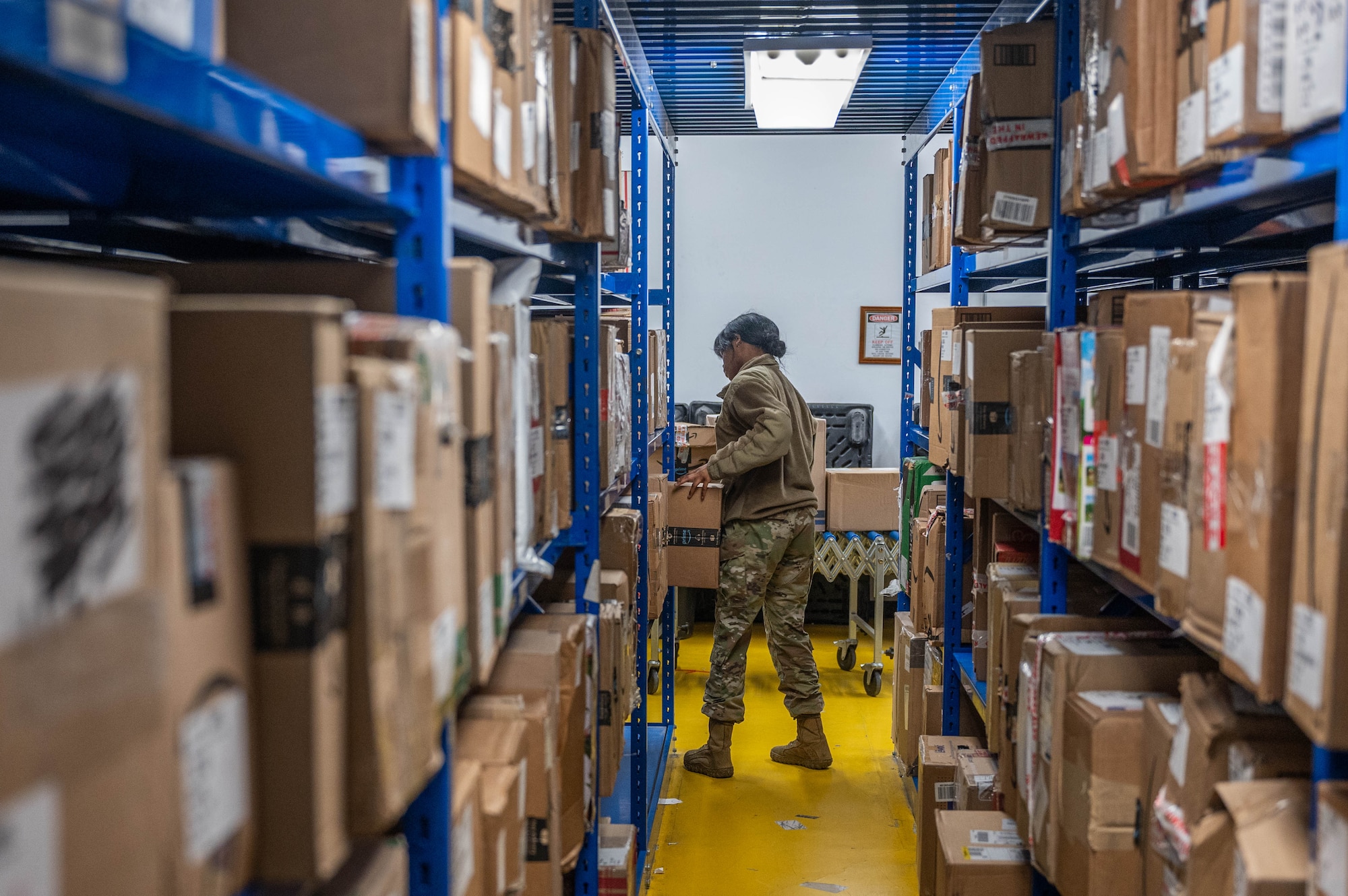 U.S. Air Force Airman Kennedy Sanders, 51st Force Support Squadron military postal clerk, organizes boxes in the post office at Osan Air Base, Republic of Korea, Dec. 12, 2023. The Osan Air Base Post Office is a team of 40 personnel, who are responsible for handling the mail for all base personnel, in addition to incoming and outgoing mail for 64 units on base. (U.S. Air Force photo by Airman 1st Class Chase Verzaal)
