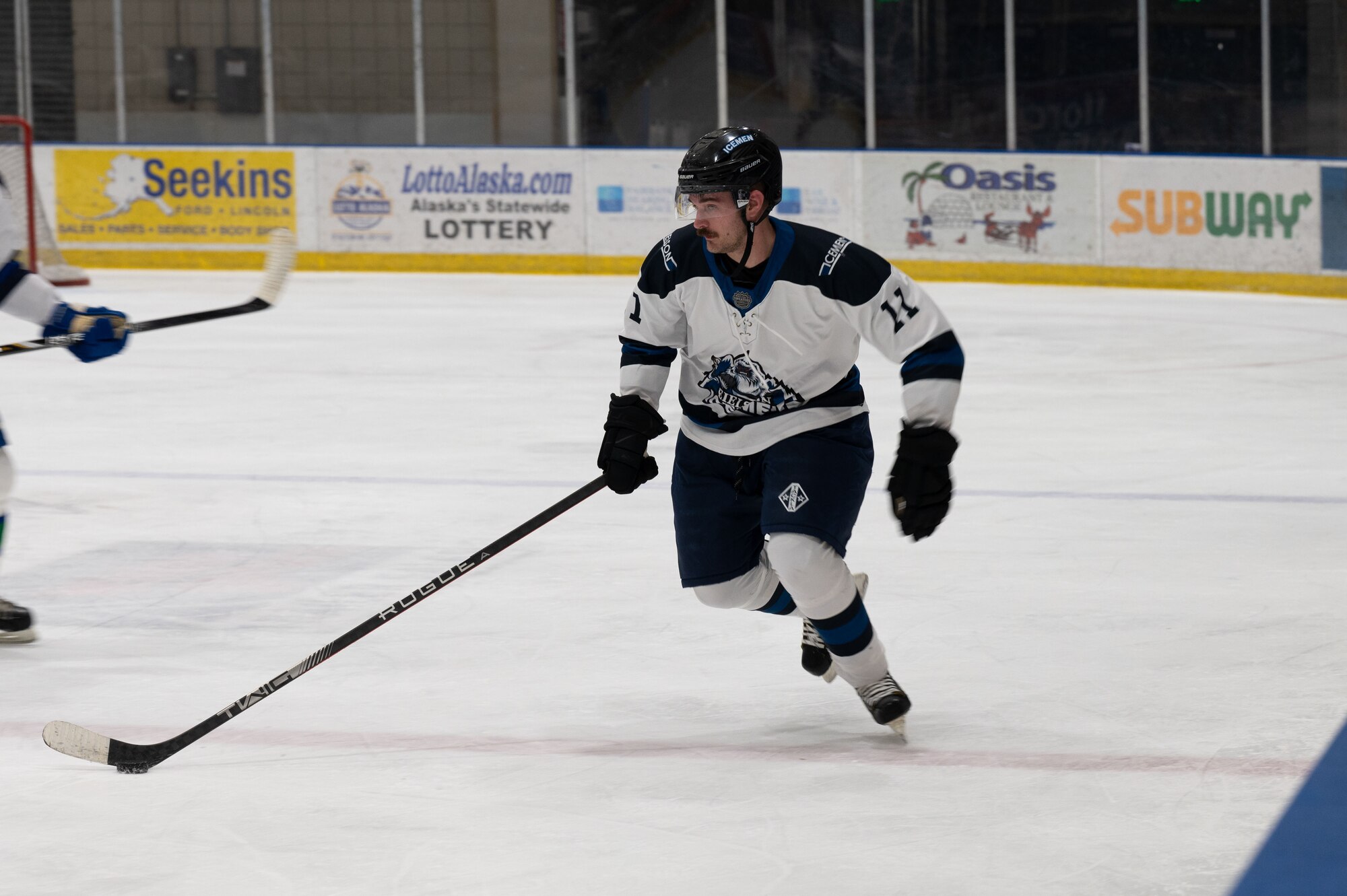 U.S. Air Force Staff Sgt. Jonathon Spaller, 354th Maintenance Group squadron lead crew chief, moves the puck down the ice in Fairbanks, Alaska, Nov. 26, 2023.