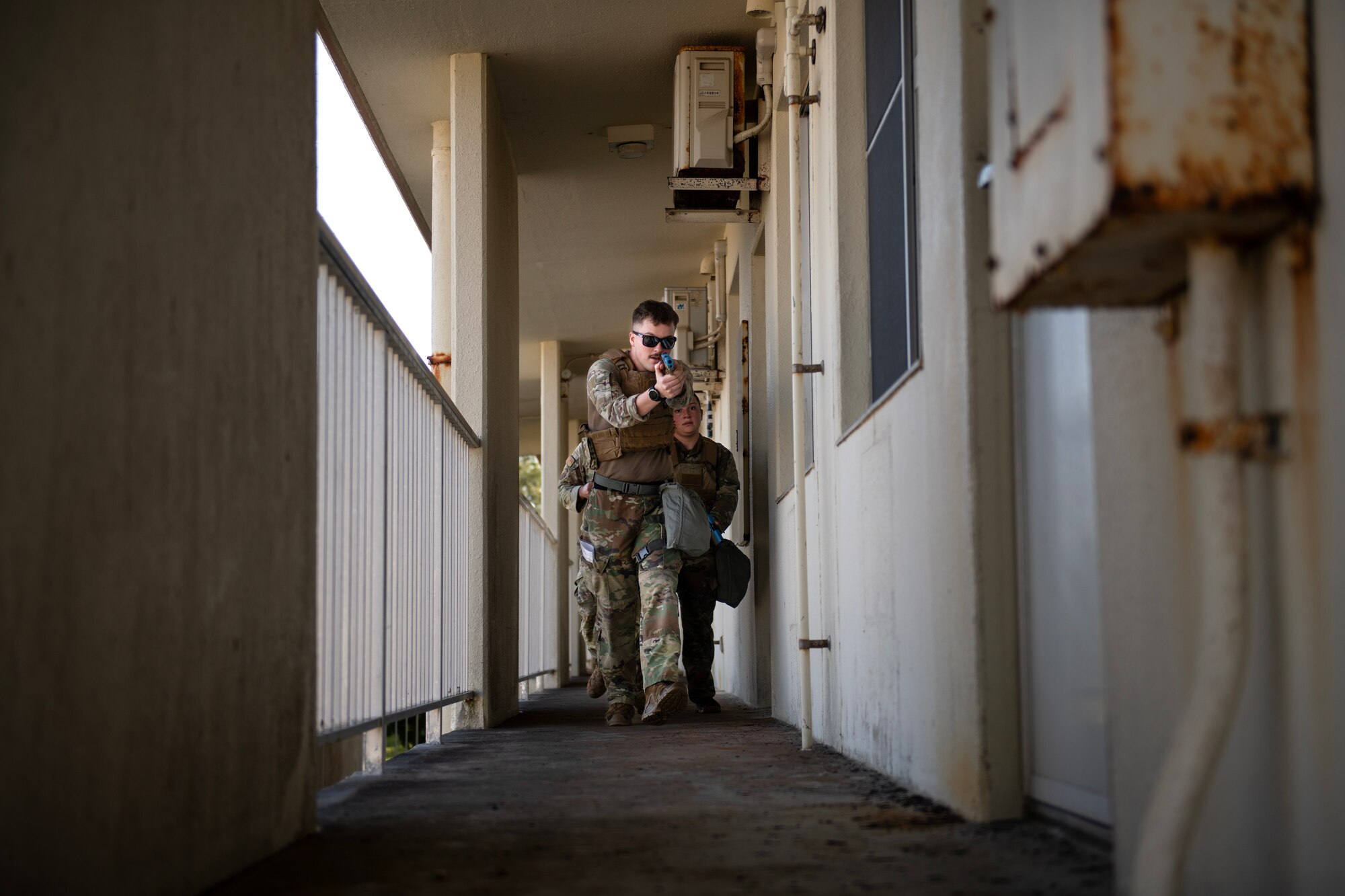 military member walks crouched down a hallway