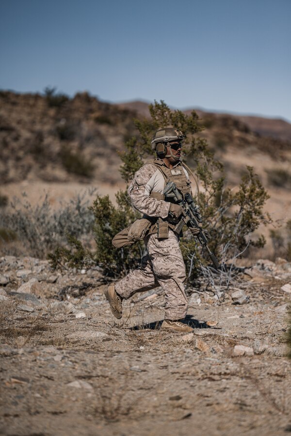 U.S. Marine Corps Lance Cpl. Jeovany Rosales, an infantry Marine with 3rd Battalion, 4th Marine Regiment (REIN), 7th Marine Regiment, 1st Marine Division, runs toward a simulated urban terrain at Range 230 during Exercise Steel Knight 23.2 at Marine Corps Air-Ground Combat Center, Twentynine Palms, California, Dec. 5, 2023. Steel Knight is a three-phase exercise designed to train I Marine Expeditionary Force in the planning, deployment and command and control of a joint force against a peer or near-peer adversary combat force and enhance existing live-fire and maneuver capabilities of the Marine Air-Ground Task Force. (U.S. Marine Corps Photo by Lance Cpl. Justin J. Marty)