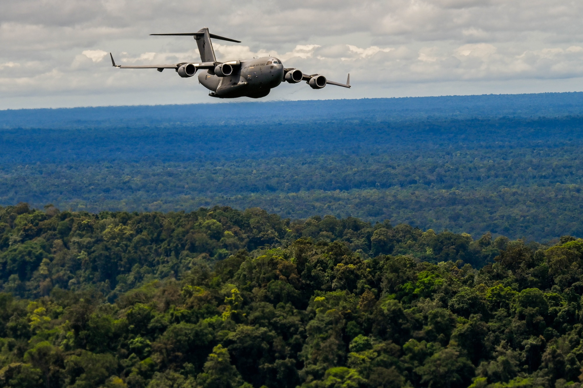 A Royal Australian Air Force C-17 Globemaster III flies in a training flight formation during Exercise Global Dexterity 23-24 around the skies of Papua New Guinea, Dec. 6, 2023. The exercise demonstrates the key partnership and interoperability between the U.S. and Australia that allows continued security and stability in the Indo-Pacific region. (U.S. Air Force photo by Senior Airman Makensie Cooper)