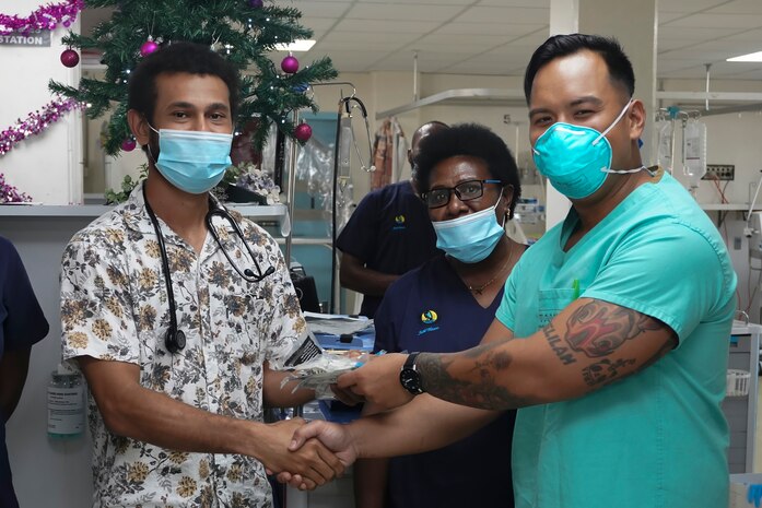 Members of the U.S. Army's 8th Forward Resuscitative and Surgical Detachment, 18th Medical Command, (2nd from the right) Port Moresby General Hospital Director of Medical Services Dr. Kone Sobi, and U.S. Army Maj. Levi Daugherty, trauma surgeon, Brooke Army Medical Center, pose for a group photo during the inaugural Papua New Guinea Trauma Rotation at Port Moresby General Hospital at Port Moresby, Papua New Guinea, Dec. 7, 2023. The Trauma Rotation follows the recent signing of the Defense Cooperation Agreement between the U.S. and Papua New Guinea; it is a first-of-its-kind engagement between the U.S. Army and Papua New Guinea, which mutually offers parties the a chance to exchange medical expertise and techniques in an austere environment. (U.S. Army photo by Sgt. 1st Class Timothy Hughes/Released)