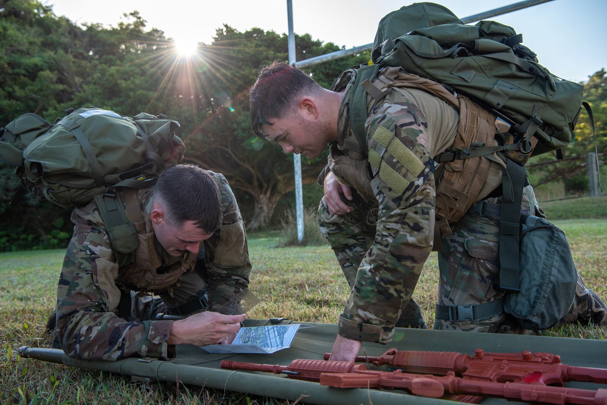 military members on the ground reading a map and plotting coordinates