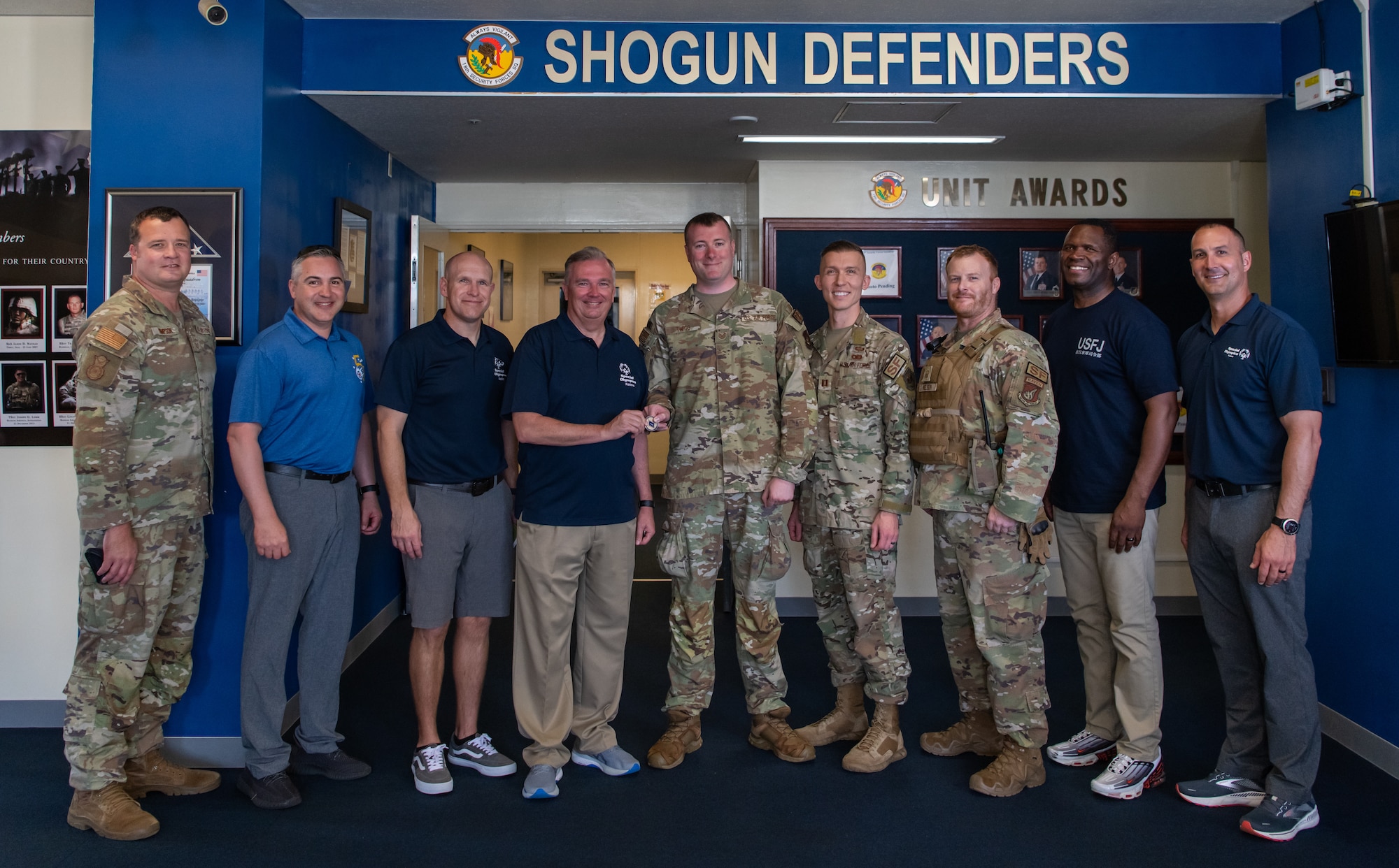 U.S. Service members pose with a coin.