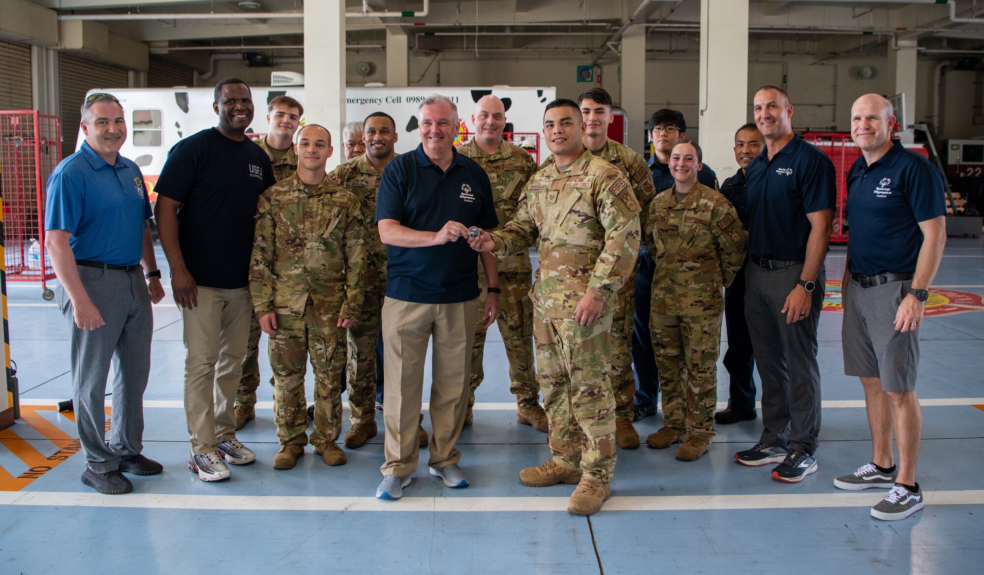 U.S service members pose with a coin.