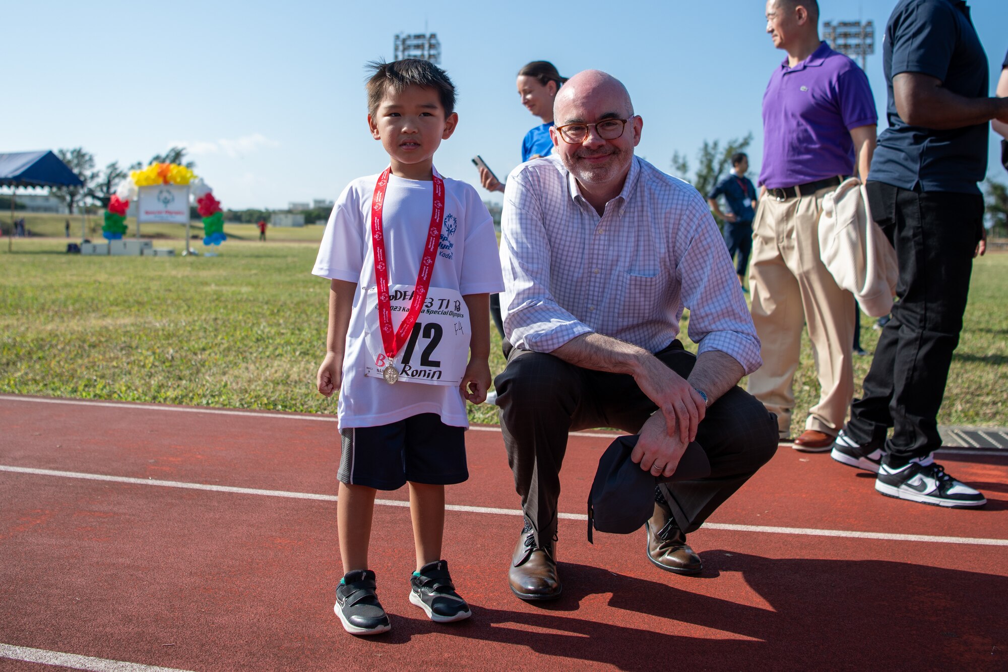 An athlete and a man pose for a photo.