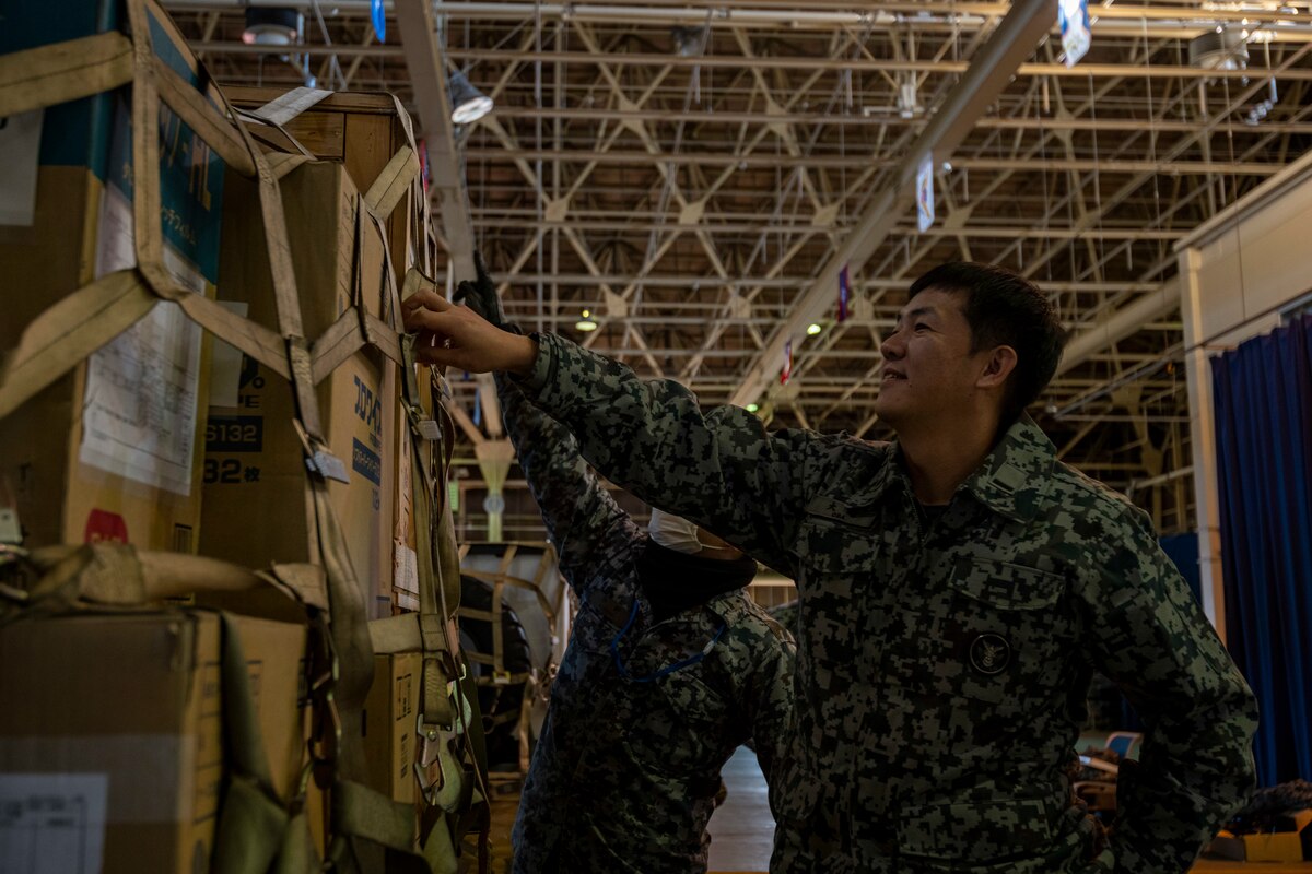 Japan Air Self-Defense Force (JASDF) members look over the work of another team during a Port Dawg Challenge at Misawa Air Base, Japan, Dec. 8, 2023.