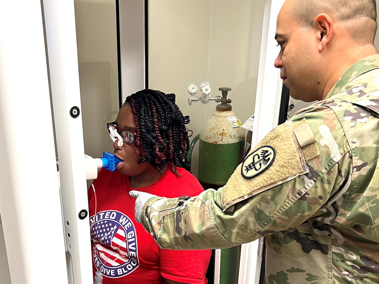 Soldier conducting a pulmonary function test on a patient.