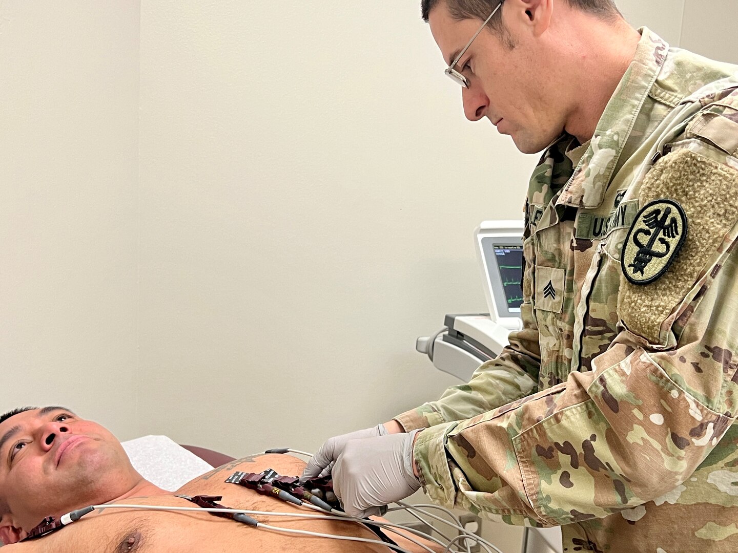 Soldier conducting an EKG on a patient.