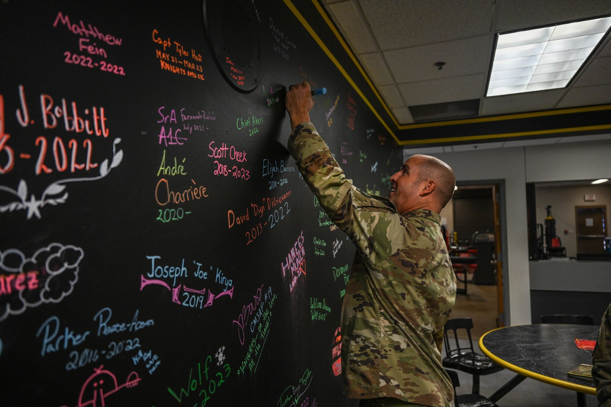 A military member writes on a chock board.