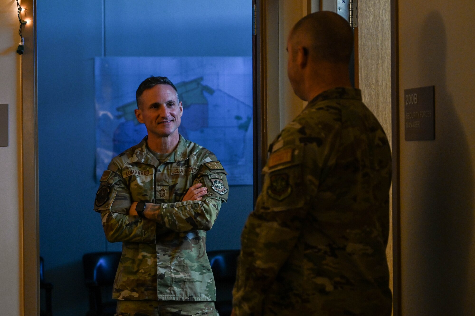 Two Air Force Military Members talking in a hallway.