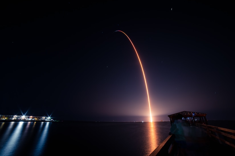 A rocket flies across a night sky.