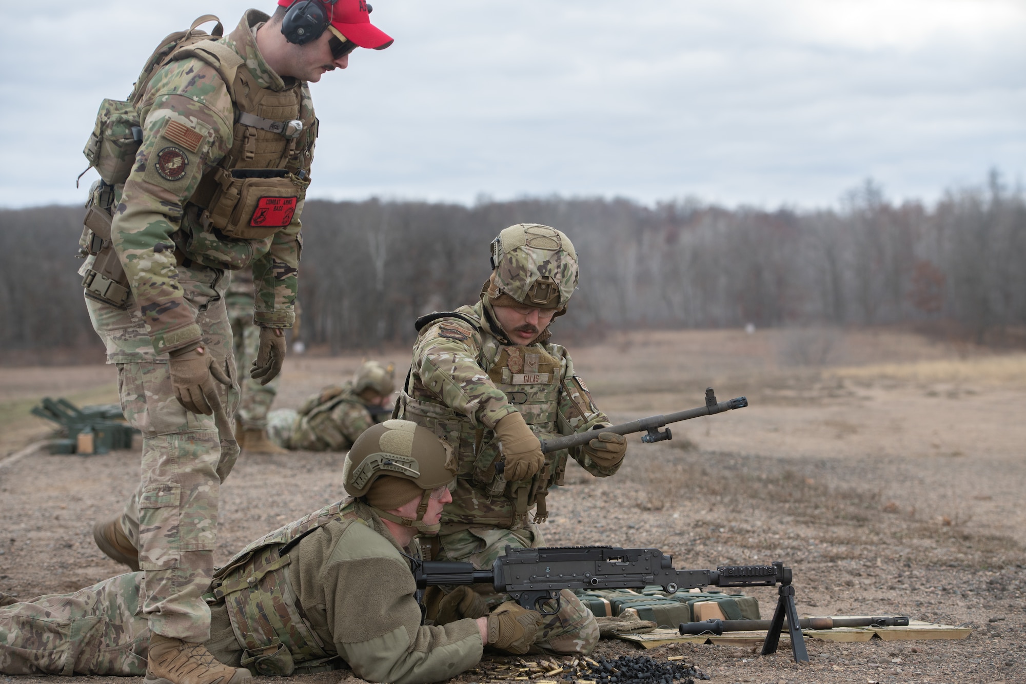 3 men look at a machine gun.