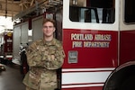 Airman 1st Class Stephen Warren, a firefighter with the 142nd Civil Engineer Squadron, poses next to a fire engine at Portland Air National Guard Base, Ore., November 5, 2023.