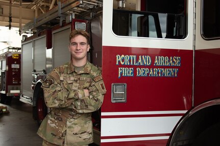 Airman 1st Class Stephen Warren, a firefighter with the 142nd Civil Engineer Squadron, poses next to a fire engine at Portland Air National Guard Base, Ore., November 5, 2023.