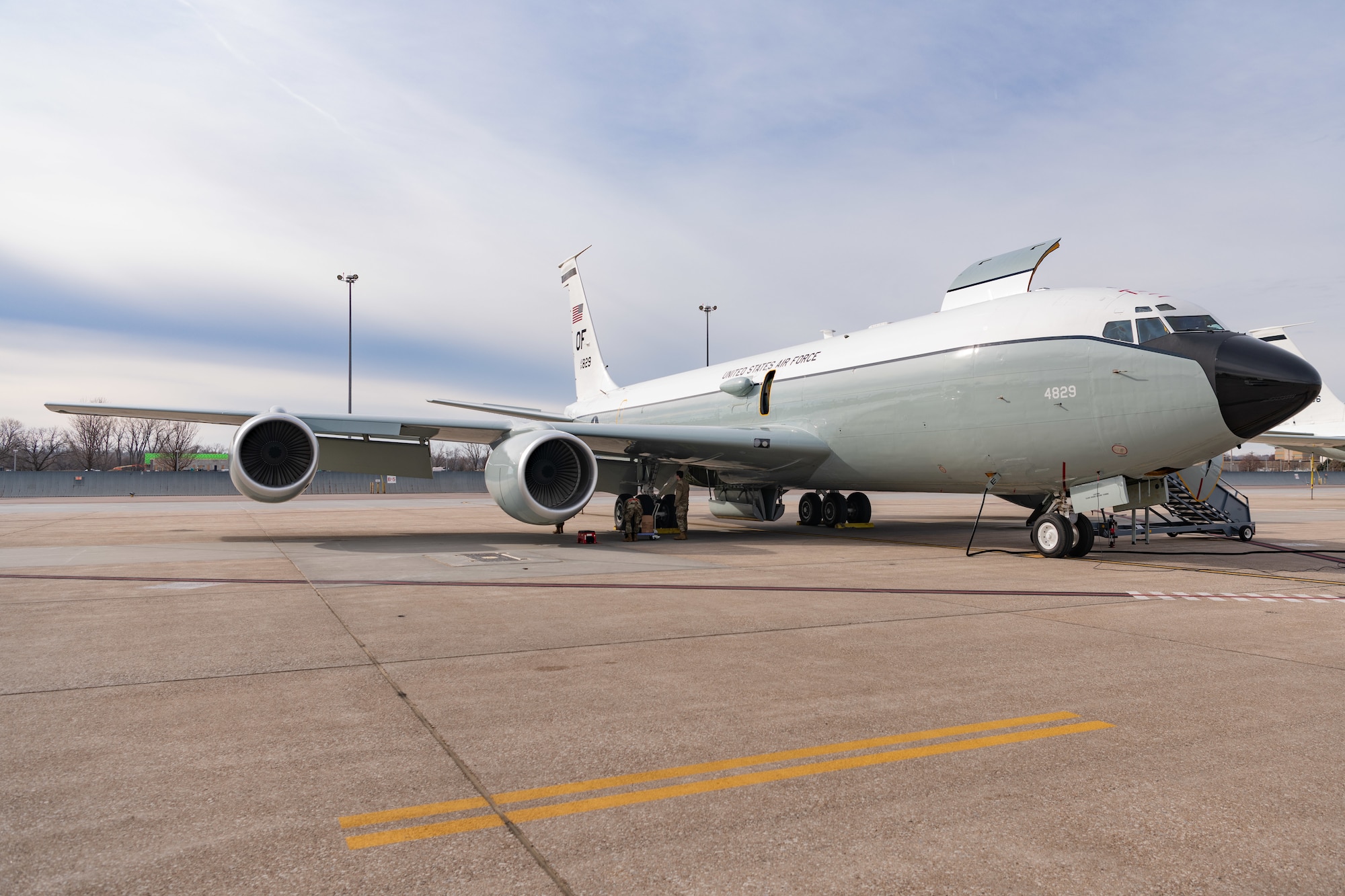 Large grey and white four engine jets sits on tarmac after landing.