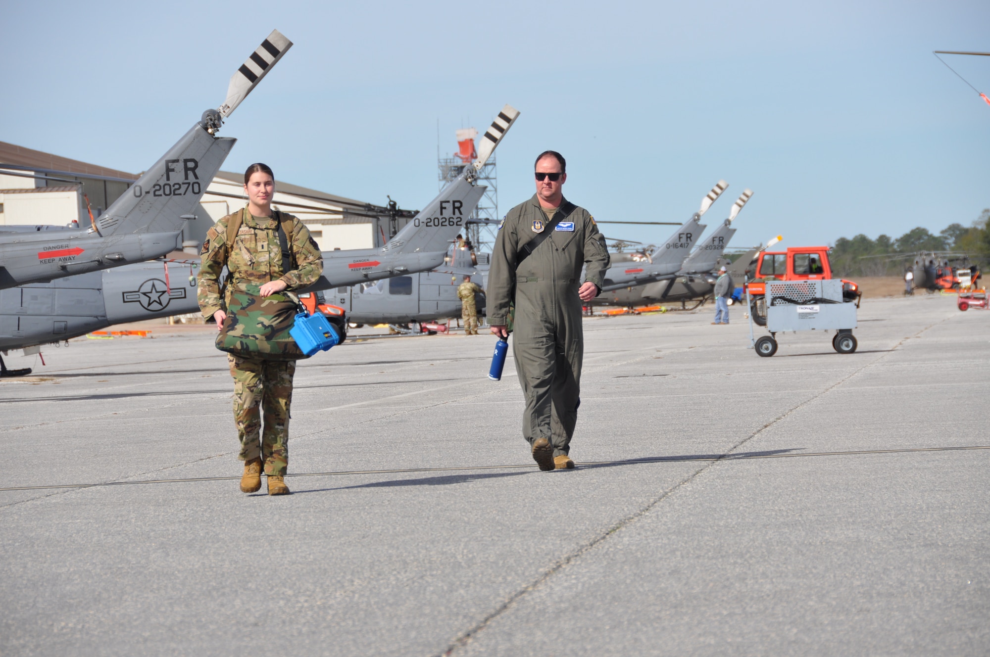 two people walk to a helicopter