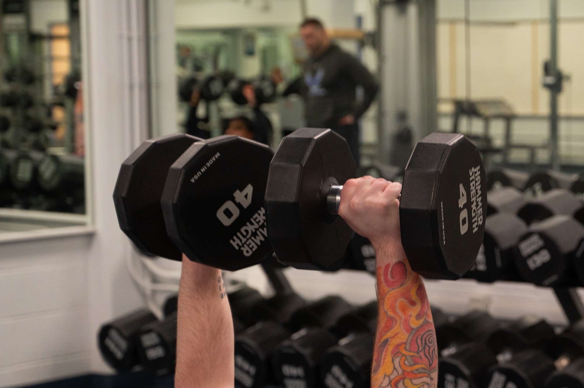A U.S. Air Force member from the 354th Security Forces Squadron lifts weights during an OST fitness session.