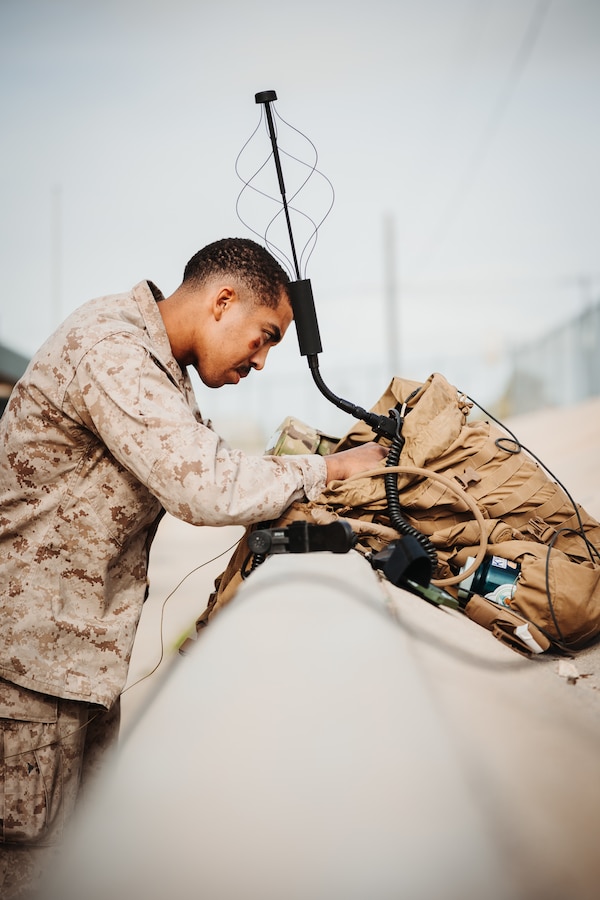 U.S. Marine Corps Cpl. Toneeskylar Diaz, a Framingham, Massachusetts native, field radio operator with 3rd Battalion, 4th Marine Regiment (REIN), 7th Marine Regiment, tests a radio during an Expeditionary Communications Course at Marine Corps Air-Ground Combat Center, Twentynine Palms, California, Nov. 15, 2023. ECC trains Marines in expeditionary skillsets that enable them to operate in any environment across the full range of military operations. (U.S. Marine Corps photo by Lance Cpl. Richard PerezGarcia)