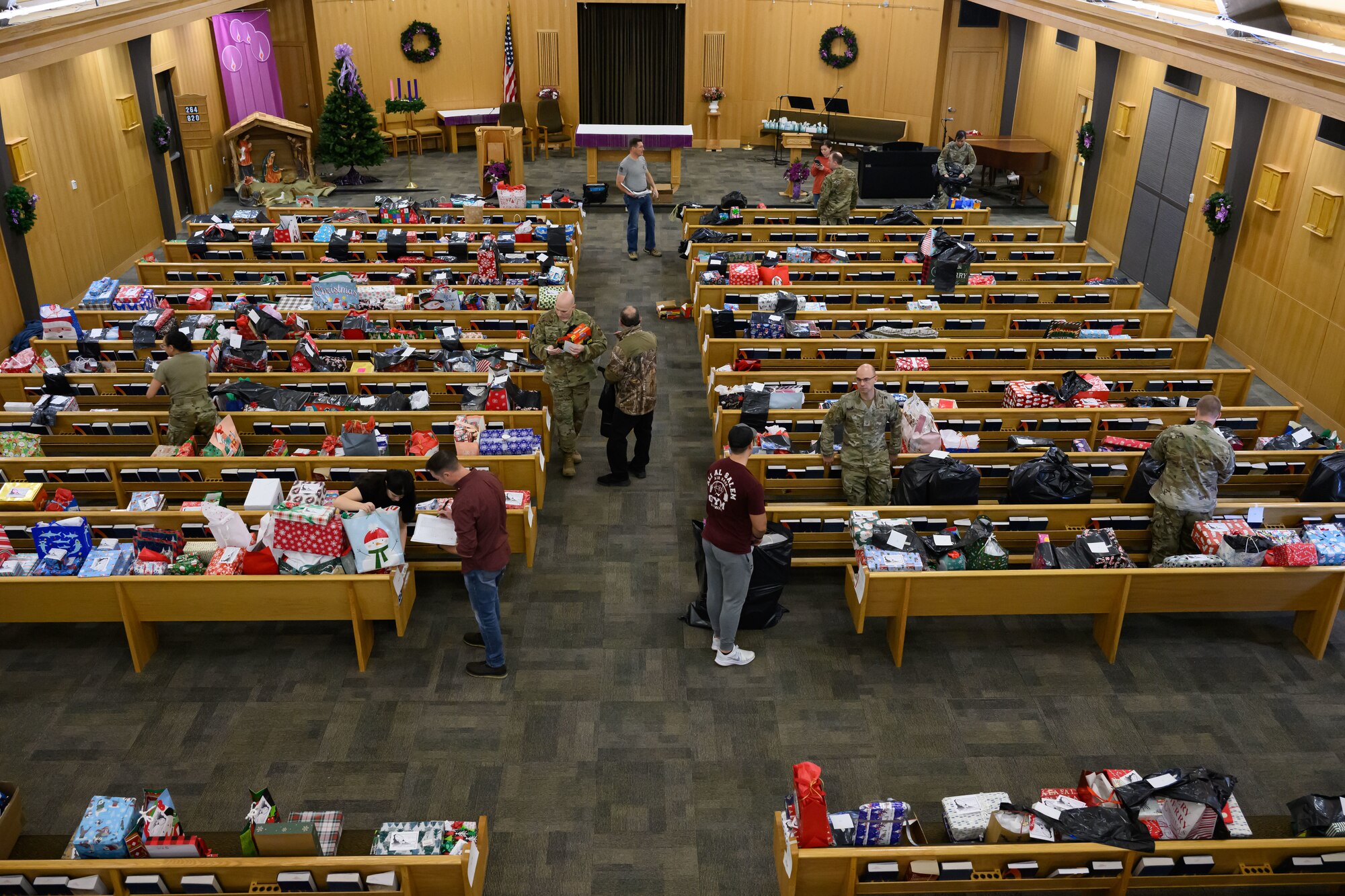 Hundreds of wrapped Christmas presents are sorted on pews in the chapel.