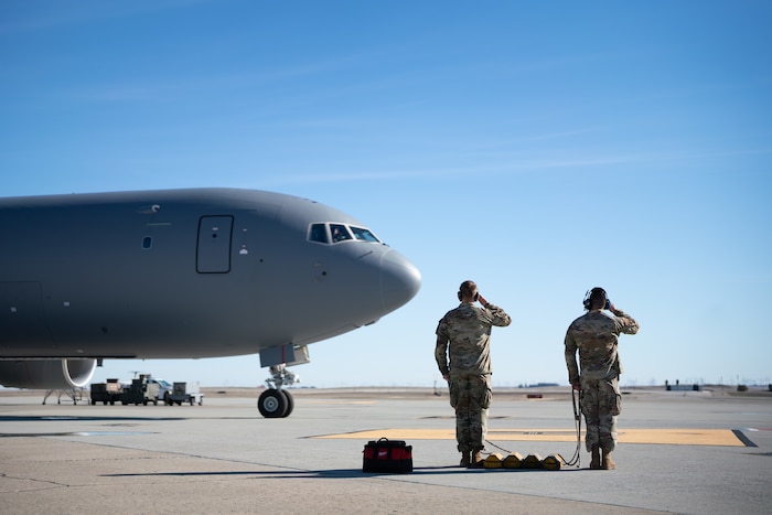 Airmen salute an aircraft