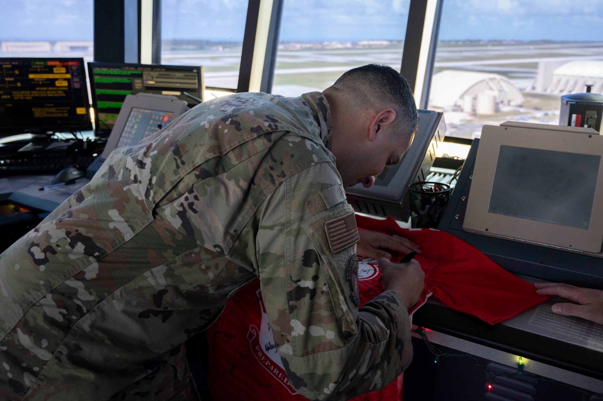 U.S. Air Force Staff Sgt. Justin Vaillant, the air traffic control tower senior watch supervisor, signs the official Linebacker of the Week jersey at Andersen Air Force Base, Guam, Dec. 6, 2023. The Team Andersen Linebacker of the Week recognizes outstanding enlisted, officer, civilian and total force personnel who have had an impact on achieving Team Andersen’s mission, vision and priorities. (U.S. Air Force photo by Senior Airman Class Emily Saxton)
