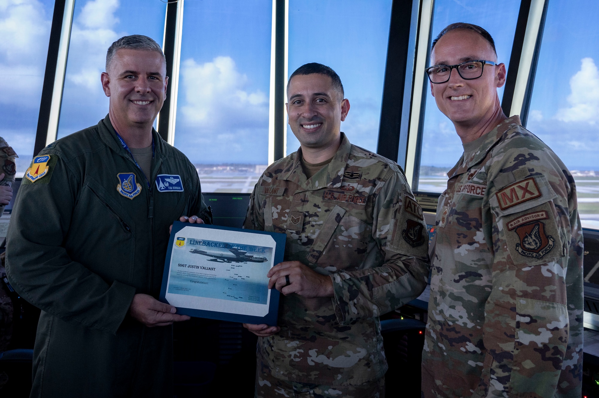U.S. Air Force Staff Sgt. Justin Vaillant, the air traffic control tower senior watch supervisor, receives the Linebacker of the Week Award from U.S. Air Force Col. Thomas Bowman, commander of the 36th Operations Group, and Chief Master Sgt. Daniel Powers, the senior enlisted leader of the 36th Maintenance Group, at Andersen Air Force Base, Guam, Dec. 6, 2023. The Team Andersen Linebacker of the Week recognizes outstanding enlisted, officer, civilian and total force personnel who have had an impact on achieving Team Andersen’s mission, vision and priorities. (U.S. Air Force photo by Senior Airman Emily Saxton)