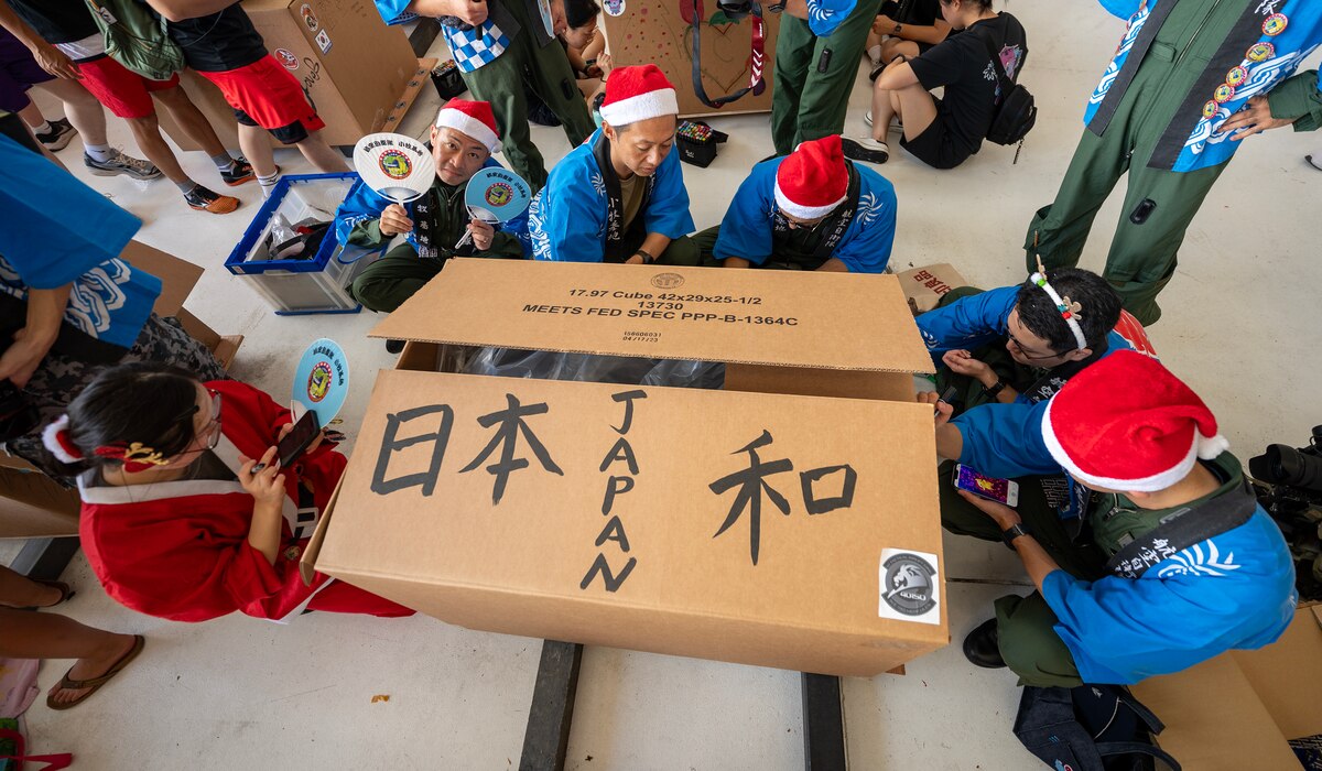 Men decorate a box with holiday messages from Japan