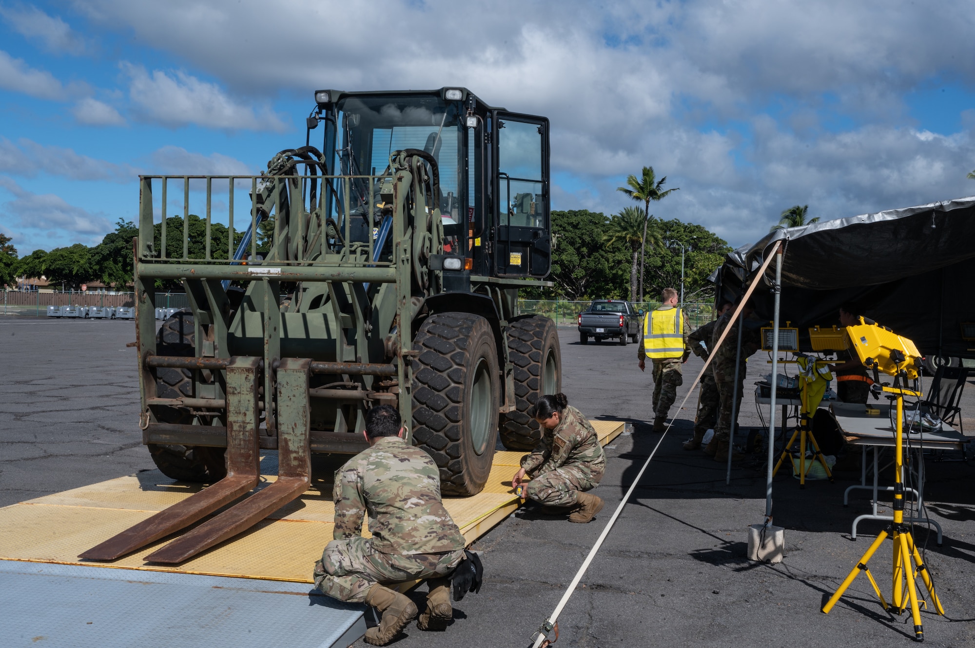 Airmen assigned to Joint Base Pearl Harbor-Hickam measure the weight of a forklift during Readiness Exercise 24-01 at JBPHH, Hawaii, Dec. 12, 2023. The RE provides realistic training in various operations, enabling our Airmen to provide distinct tools and capabilities needed for mission success in an ever-changing theater. (U.S. Air Force photo by Staff Sgt. Alan Ricker)