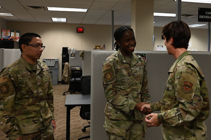 U.S. Air Force Chief Master Sgt. Kristina Montgomery, 2nd Air Force command chief, coins Airman 1st Class Raphae Guthrie, 17th Force Support Squadron personnelist, during her visit at the Norma Brown building, Goodfellow Air Force Base, Texas, Dec. 7, 2023. Montgomery coined Guthrie for her dedication to accomplishing student assignments inside the military personnel flight. (U.S. Air Force photo by Airman 1st Class Evelyn D’Errico)