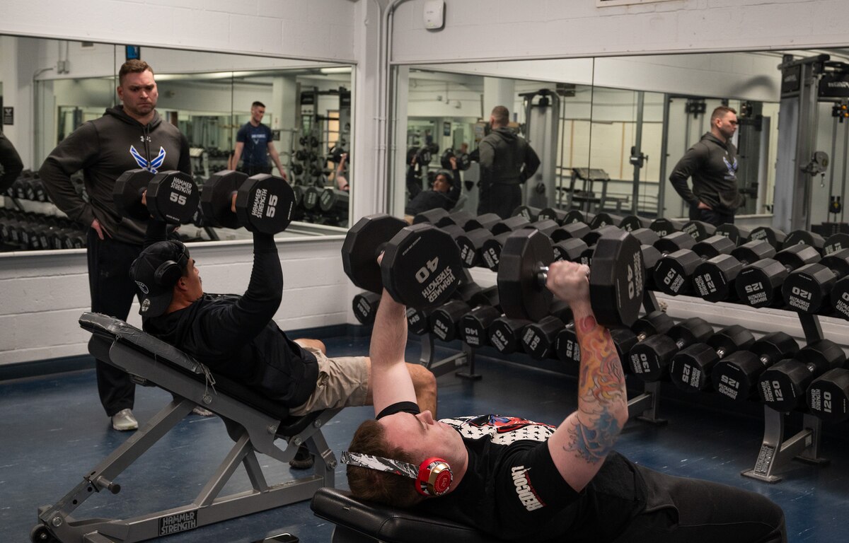 U.S. Air Force Maj. Miles Stutes, 354th Medical Group Operational Support Team physical therapist (left) supervises a physical training session with members from the 354th Security Forces Squadron.