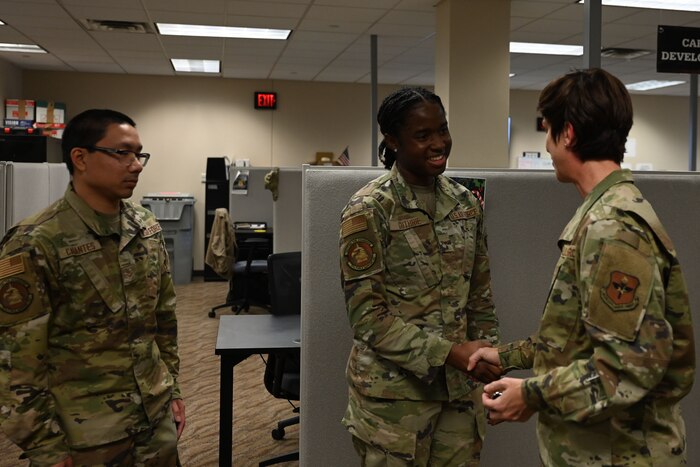 U.S. Air Force Chief Master Sgt. Kristina Montgomery, 2nd Air Force command chief, coins Airman 1st Class Raphae Guthrie, 17th Force Support Squadron personnelist, during her visit at the Norma Brown building, Goodfellow Air Force Base, Texas, Dec. 7, 2023. Montgomery coined Guthrie for her dedication to accomplishing student assignments inside the military personnel flight. (U.S. Air Force photo by Airman 1st Class Evelyn D’Errico)