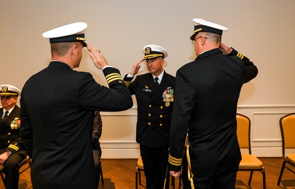 Cmdr. Michael Huber, left, salutes Capt. Brain Hogan, commodore, Submarine Squadron Eight, center, as he relieves Cmdr. Vincent Kahnke, right, as the commanding officer of the Pre-Commissioning Unit (PCU) Arkansas (SSN 800) during the boat's change of command ceremony at the Mariners' Museum and Park in Newport News, Virginia.
