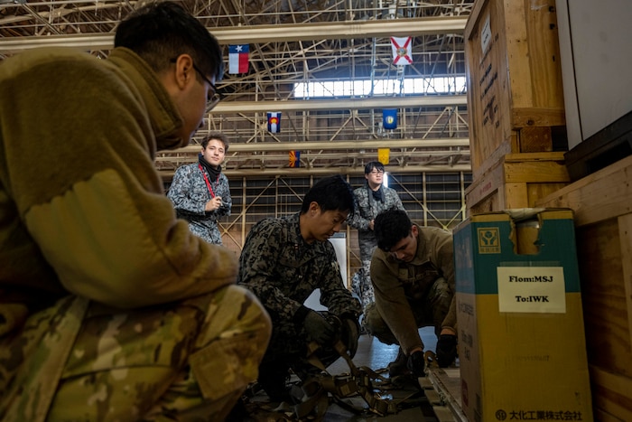 Members from the 35th Logistics Readiness Squadron and Japan Air Self-Defense Force work together to secure cargo during a Port Dawg Challenge at Misawa Air Base, Japan, Dec. 8, 2023.