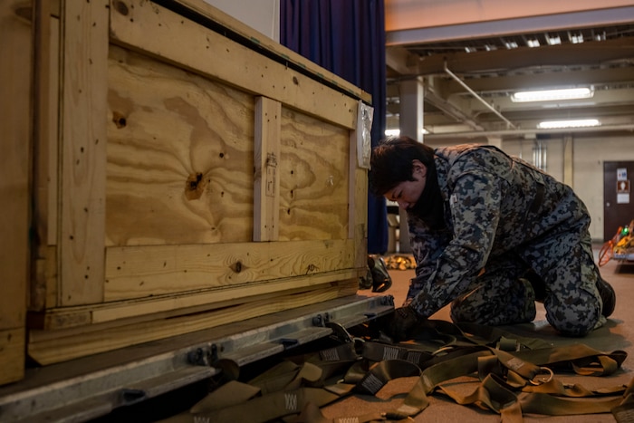 A Japan Air Self-Defense Force (JASDF) member attaches securing straps to a cargo pallet during a Port Dawg Challenge at Misawa Air Base, Japan, Dec. 8, 2023.