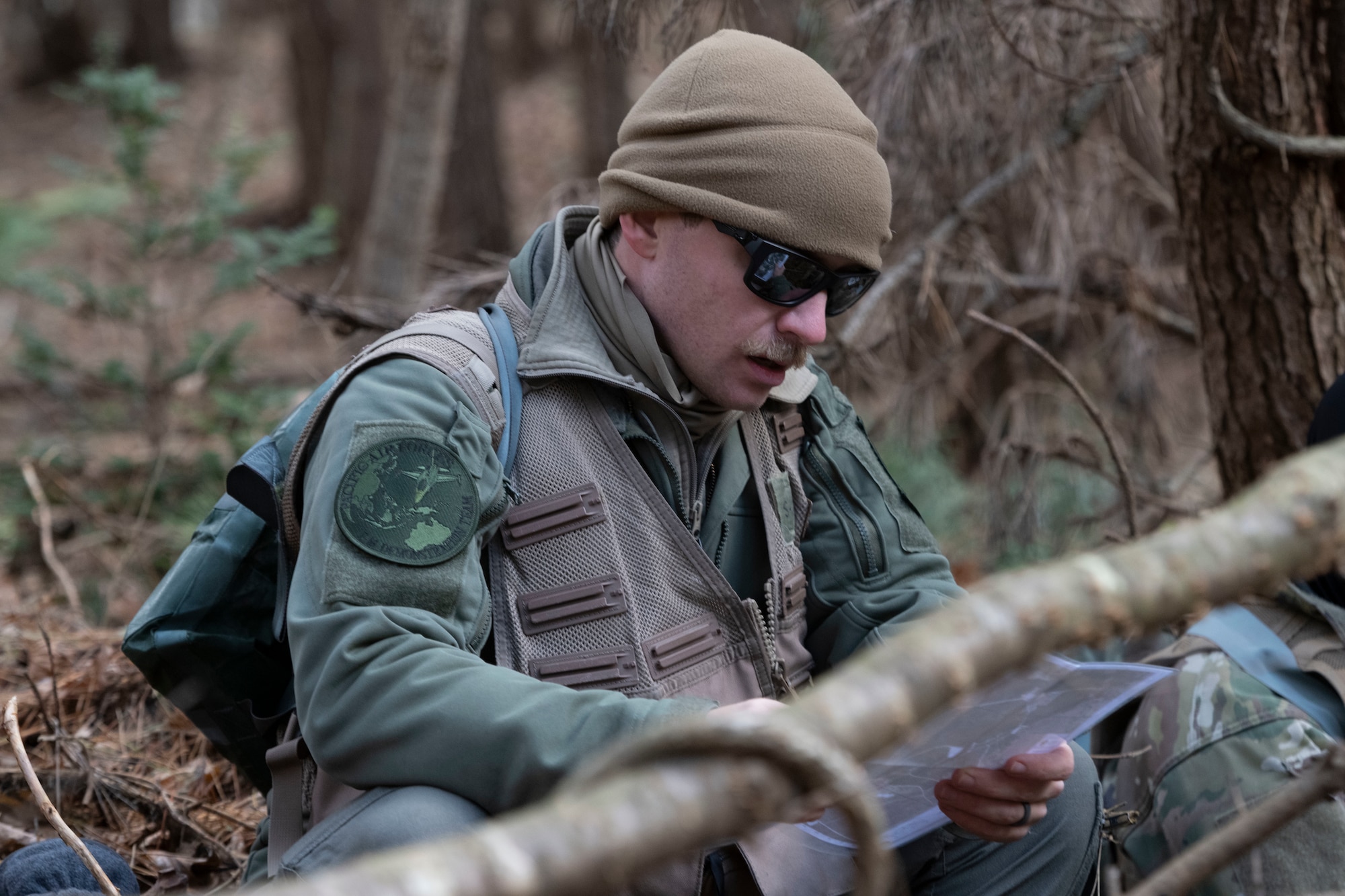 A U.S. Air Force F-16 Fighting Falcon pilot reviews a map during a combat survival skills training exercise at Draughn Range near Misawa Air Base, Japan.