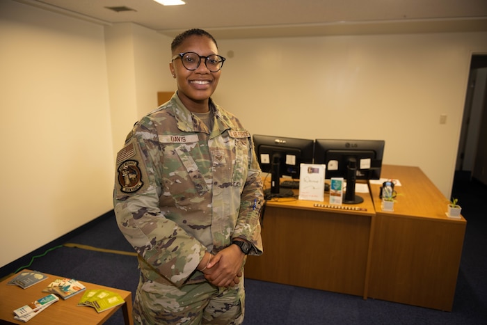U.S. Air Force Senior Airman Britney Davis, 35th Fighter Wing religious affairs, poses for a photo in front of her desk at Misawa Air Base, Japan, Dec. 12, 2023.