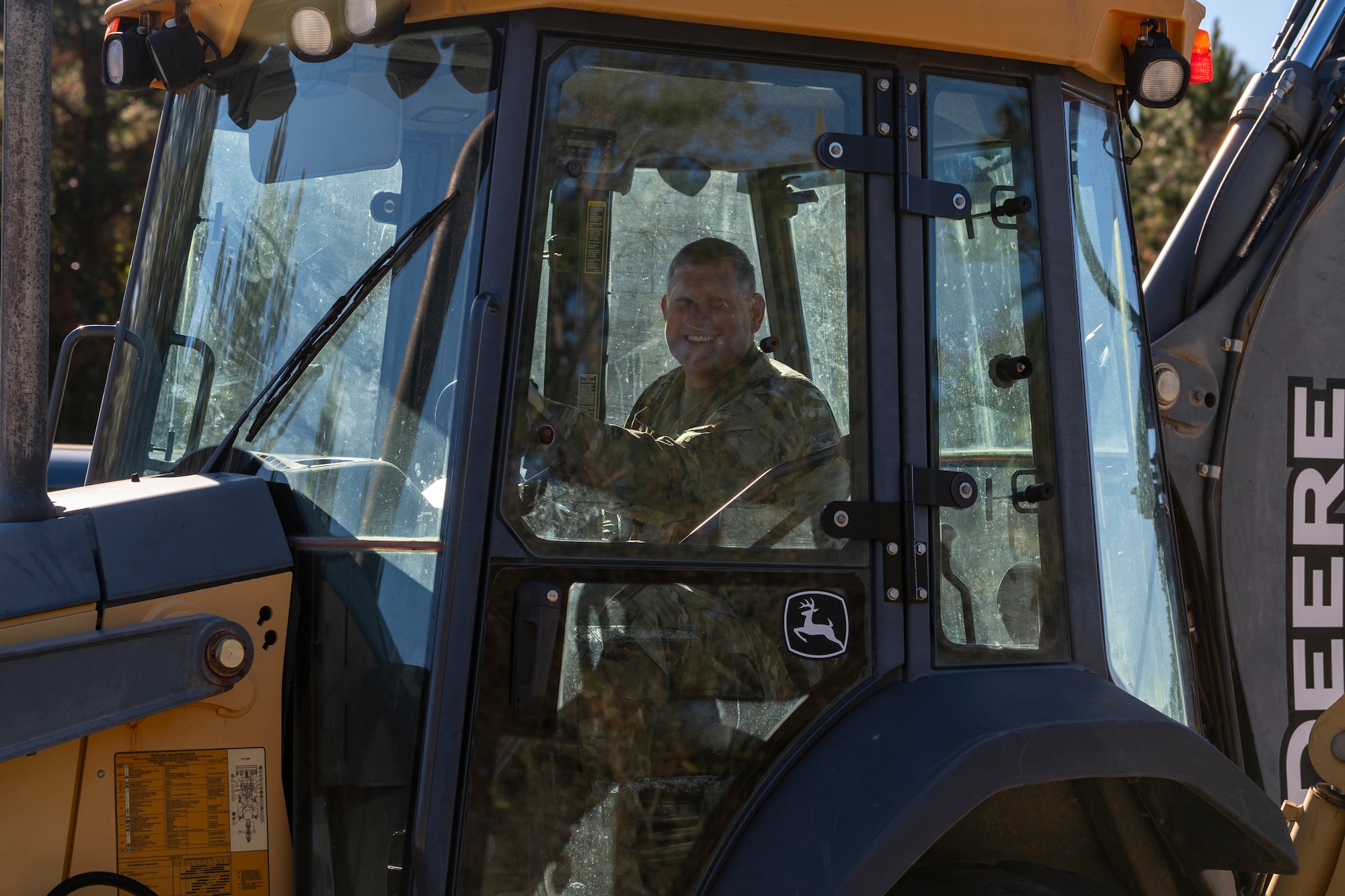 U.S. Air Force Chief Master Sgt. Justin Geers, 23rd Wing command chief, drives a backhoe
