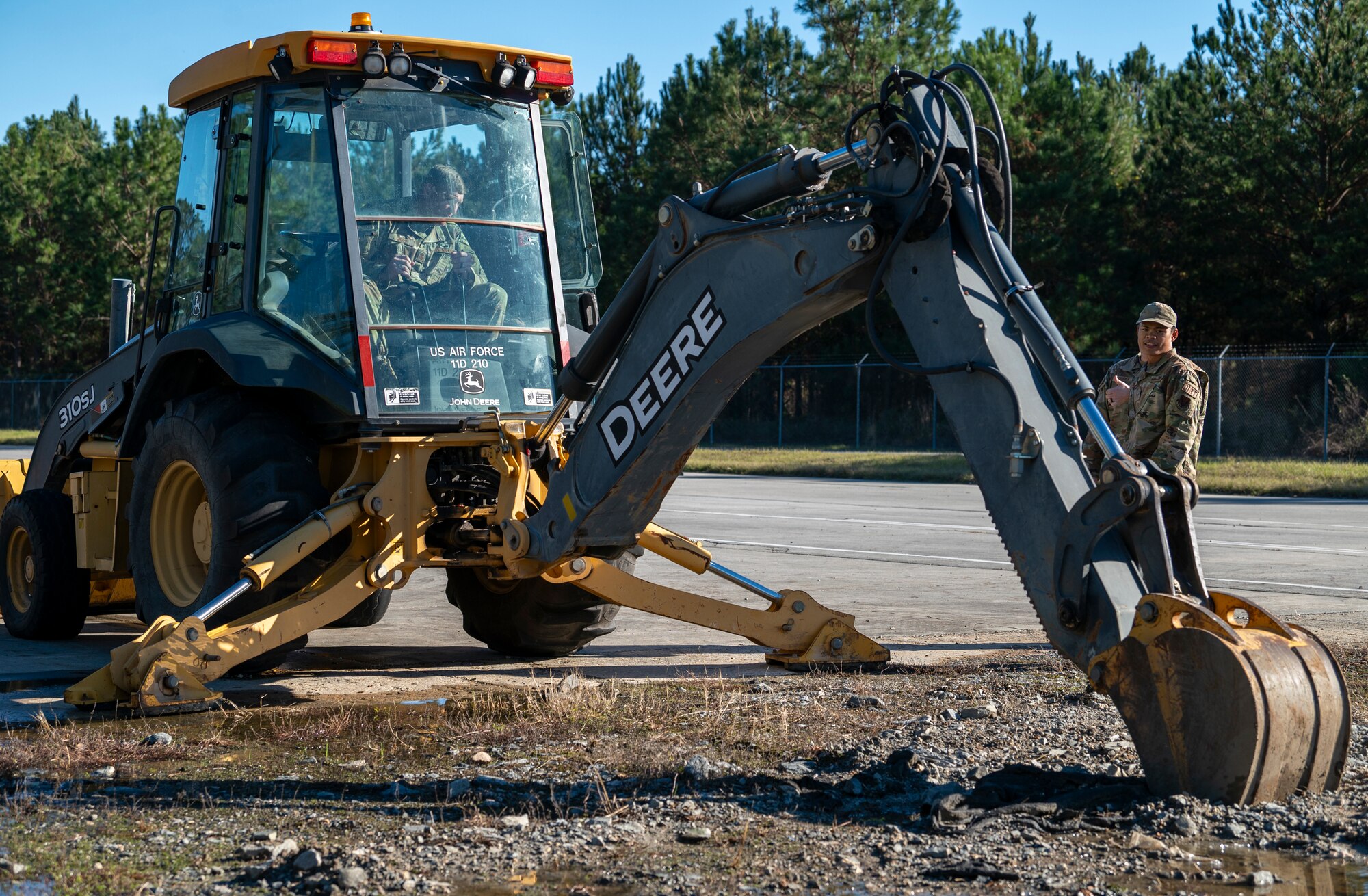 U.S. Air Force Chief Master Sgt. Justin Geers, 23rd Wing command chief, drives a backhoe