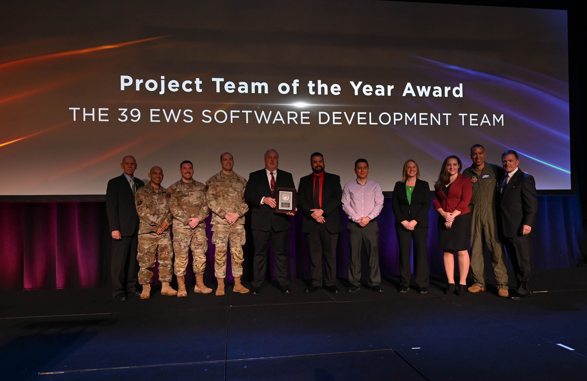 The 39th Electronic Warfare Squadron Software Development Team poses for a group photo after winning an award at the Association of Old Crows’ 2023 International Symposium and Convention in National Harbor, MD, Dec. 11, 2023. The team won the AOC Project Team of the Year in the Community Awards category for developing a software factory to increase the deployment of applications to warfighters by 83%. (U.S. Air Force photo by Capt. Benjamin Aronson)