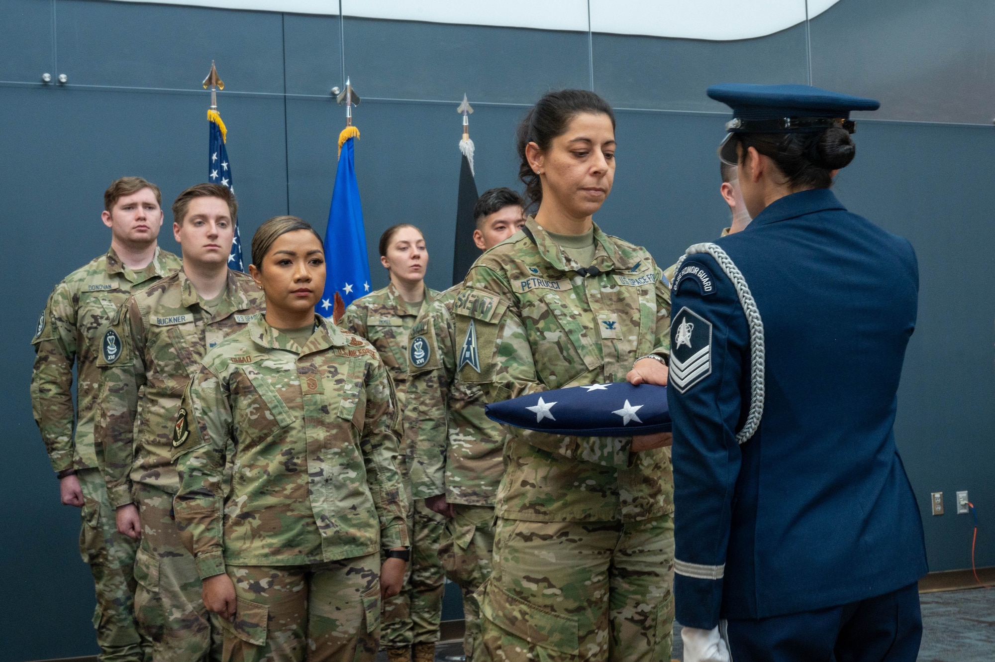 Space Force Col. Nicole Petrucci, commander of Space Delta 3 – Space Electromagnetic Warfare, receives a folded American flag from a member of the Peterson Space Force Base color guard during the 16th Electromagnetic Warfare Squadron’s Flag Folding Ceremony at Peterson SFB Dec. 7, 2023. The ceremony celebrated Guardians and Air Force Reservists from the 160th, 161st, and 162d Deployment teams ahead of their upcoming deployments.