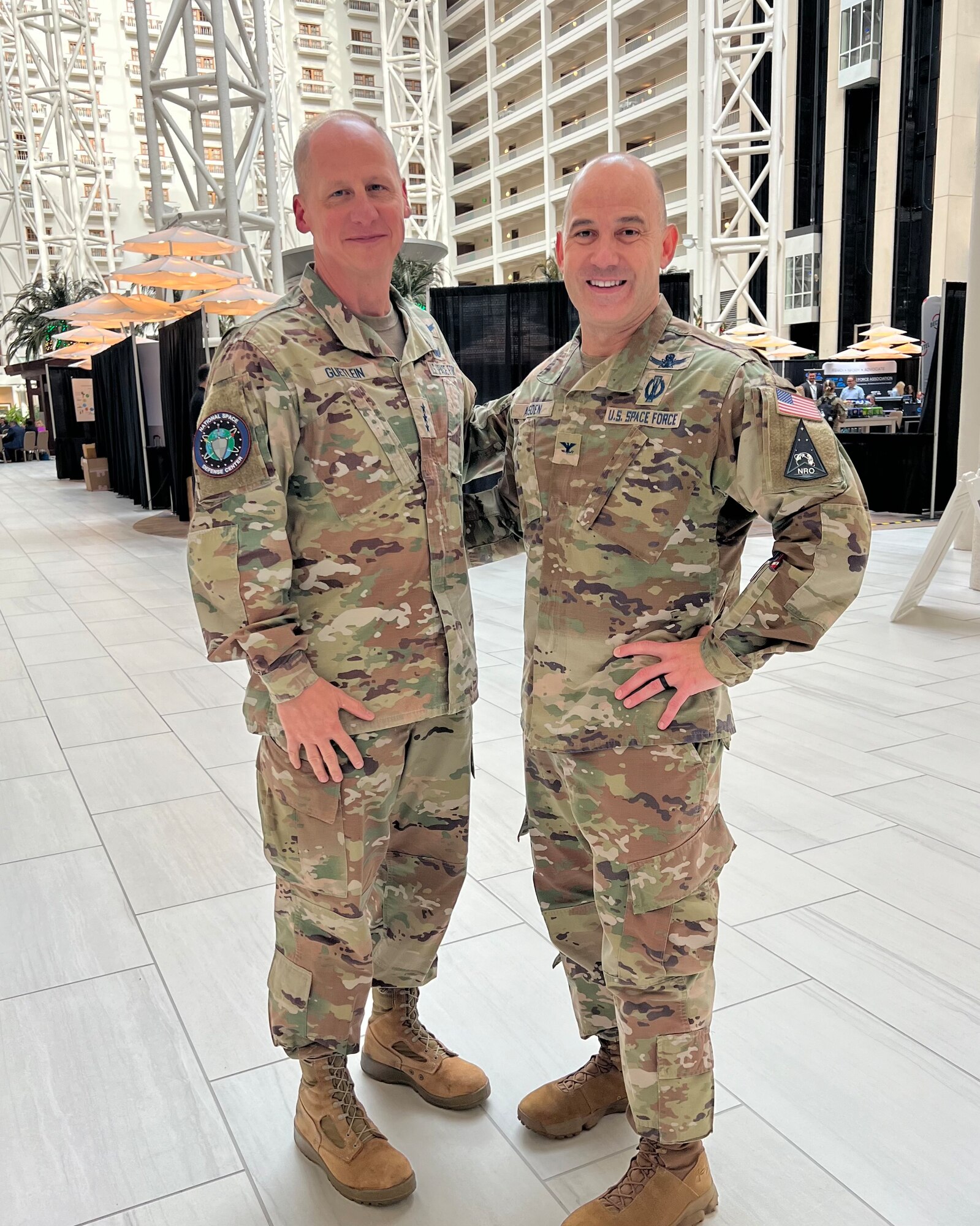 two military men in uniform pose for photo