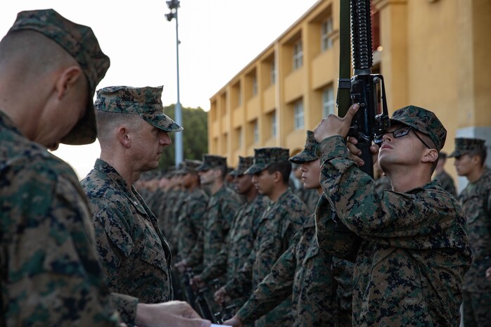U.S. Marine Corps Lt. Col. Matthew Phelps, the 3rd battalion commander, inspects U.S. Marine Corps Pfc. Andrew Knight with Lima Company, 3rd Recruit Training Battalion during a battalion commander inspection at Marine Corps Recruit Depot San Diego, Dec.13, 2023. The battalion commander’s inspection surveys new Marines knowledge, bearing, and attention to detail as one of their last tests before graduating.  Knight was recruited out of Austin, Texas. (U.S. Marine Corps photo by Lance Cpl. Sarah M. Grawcock)