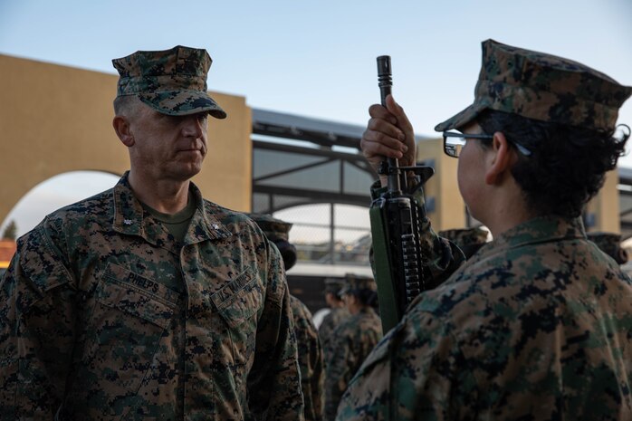 U.S. Marine Corps Lt. Col. Matthew Phelps, the 3rd battalion commander, inspects U.S. Marine Corps Pvt. Angeline Andino with Lima Company, 3rd Recruit Training Battalion during a battalion commander's inspection at Marine Corps Recruit Depot San Diego, Dec.13, 2023. The battalion commander's inspection surveys new Marines knowledge, bearing, and attention to detail as one of their last tests before graduating. Andino was recruited out of Tyler, Texas. (U.S. Marine Corps photo by Lance Cpl. Sarah M. Grawcock)