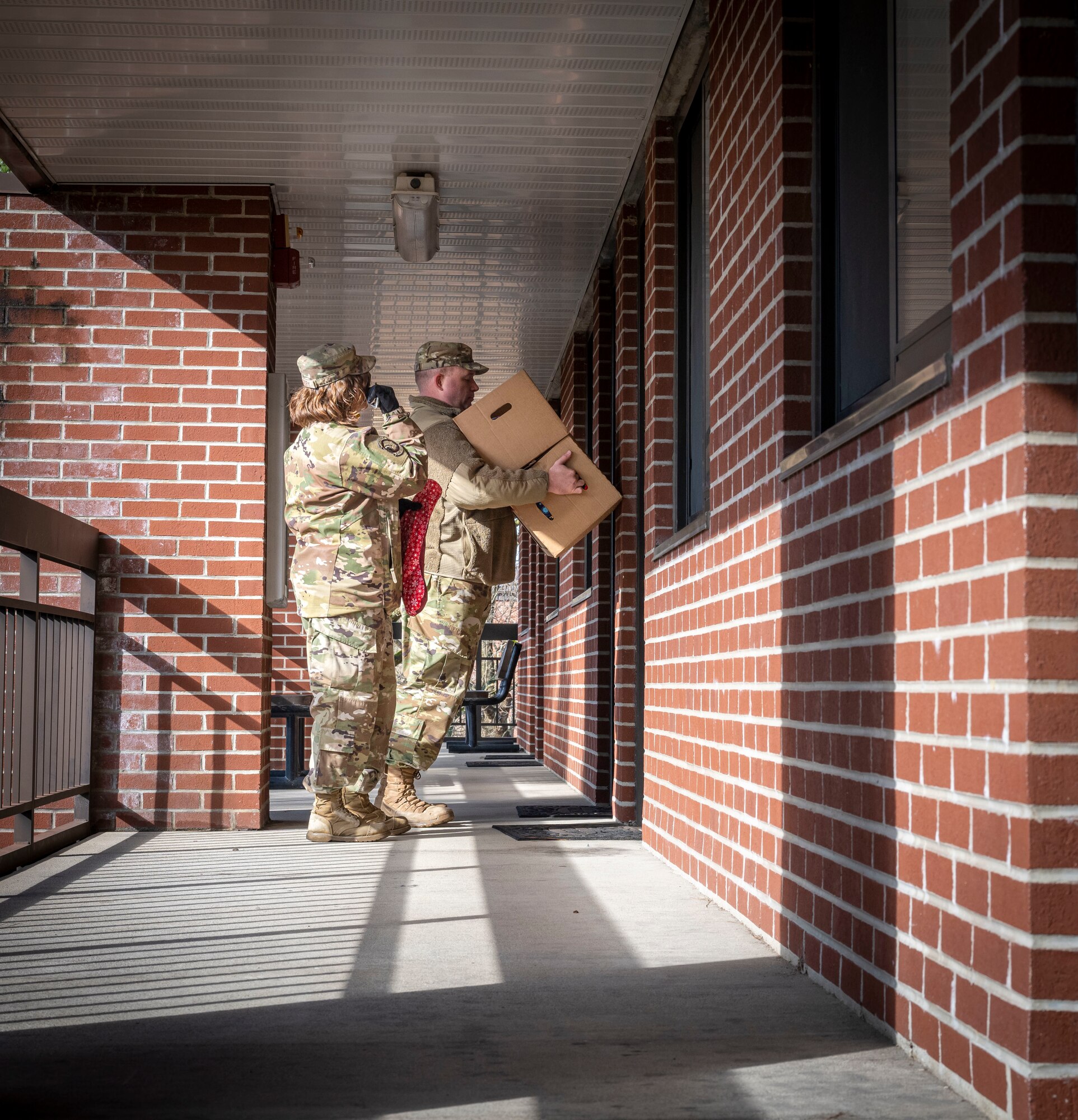 U.S. Air Force Master Sgt. Kendra McCory, left, 335th Fighter Generation Squadron first sergeant, and Master Sgt. Steven Helms, 4th Component Maintenance Squadron first sergeant, delivers holiday gift bags at Seymour Johnson Air Force Base, North Carolina, Dec. 11, 2023. The Airmen cookie drive is an annual event coordinated by the Seymour Spouse’s Club and the first sergeants to help Airmen in the dorms feel at home for the holidays. (U.S Air Force photo by Senior Airman Sabrina Fuller-Judd)