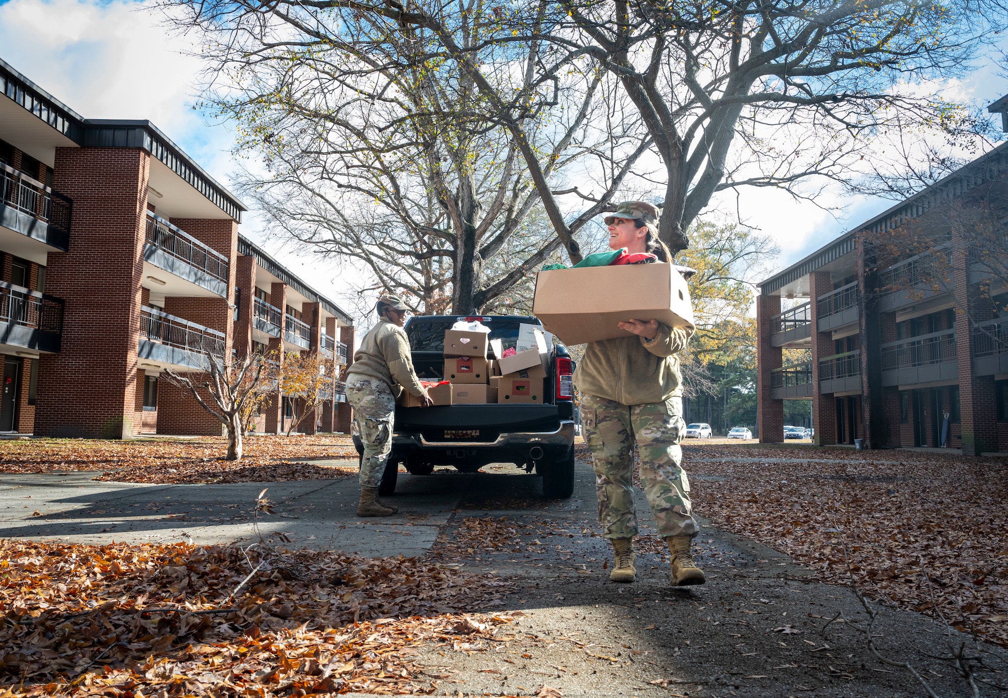 U.S. Air Force Tech. Sgt. Figaro Shimika, left, 4th Force Support Squadron assistant first sergeant, and Master Sgt. Christina Howard, right, 4th Medical Group first sergeant, unloads vehicles to distribute holiday gift bags at Seymour Johnson Air Force Base, North Carolina, Dec. 11, 2023. The 4th FW leadership promoted holiday events and celebrations for dorm Airmen to improve quality of life. (U.S Air Force photo by Senior Airman Sabrina Fuller-Judd)