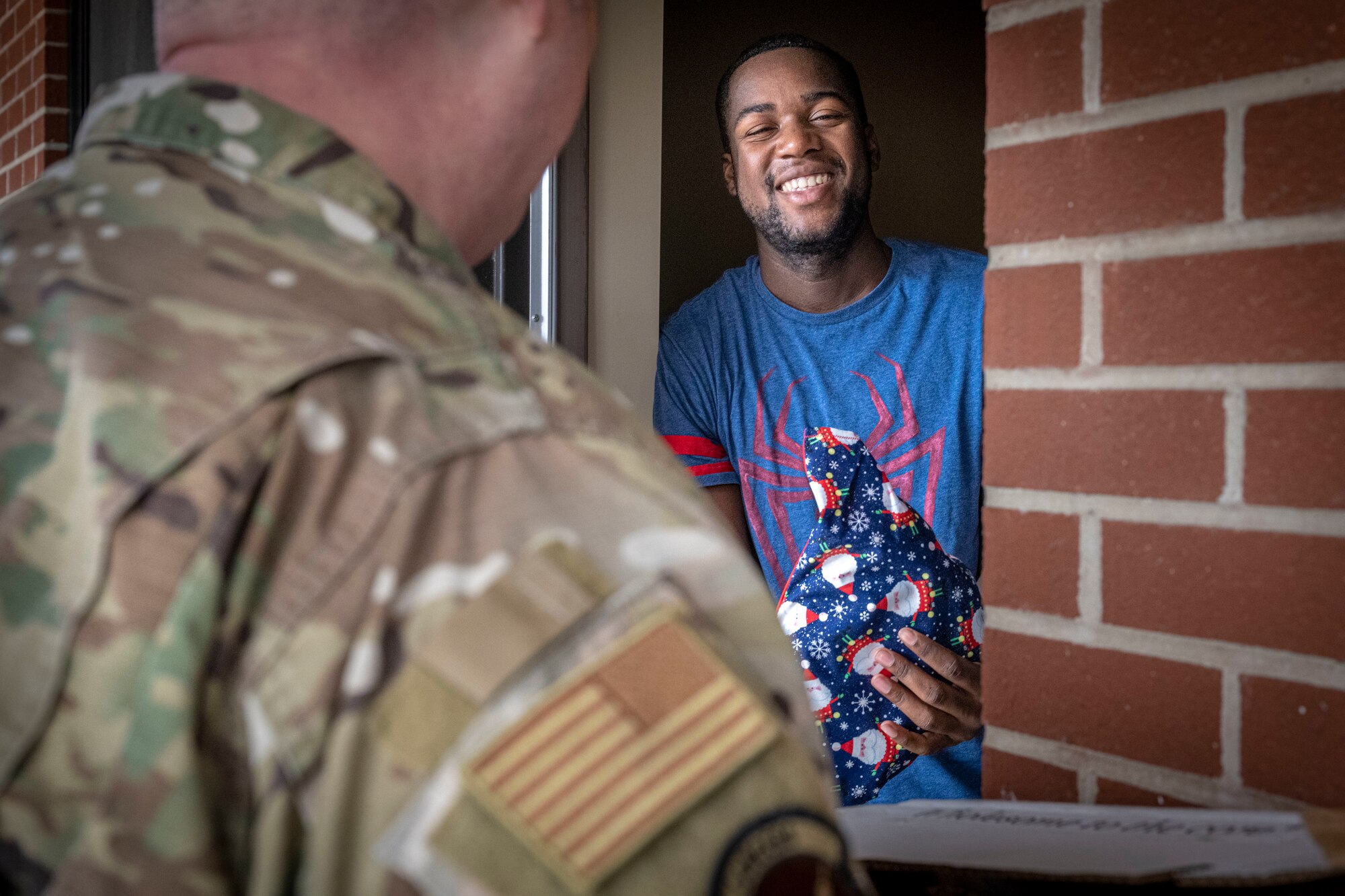 U.S. Air Force Airman assigned to the 4th Fighter Wing receive a holiday gift bag from 4th Fighter Wing first sergeants at Seymour Johnson Air Force Base, North Carolina, Dec. 11, 2023. Seymour Johnson First Shirts delivered over 700 gift bags to dorm Airmen for the holidays. (U.S Air Force photo by Senior Airman Sabrina Fuller-Judd)