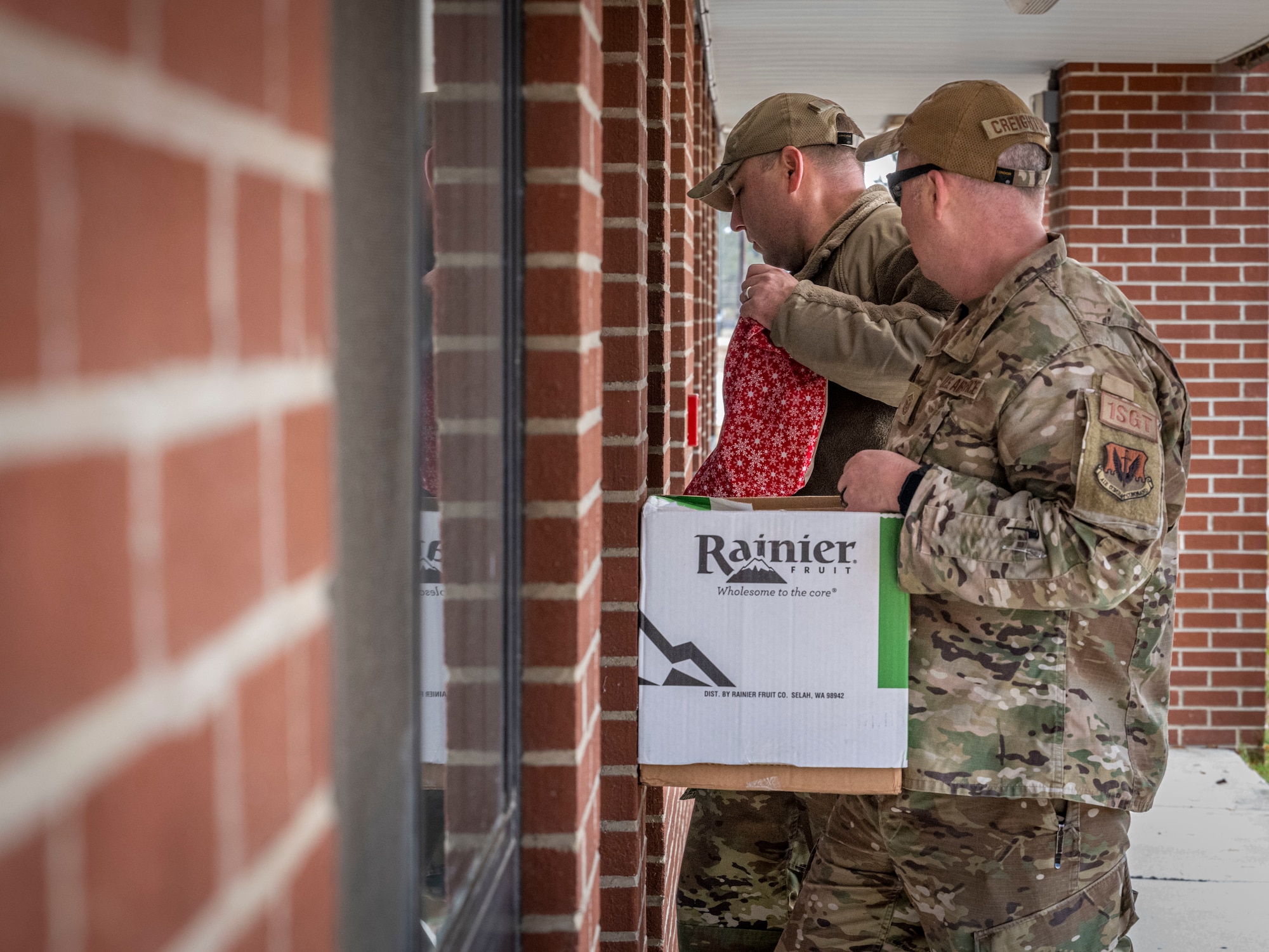 U.S. Air Force Master Sgt. Jared Madsen, left, 334th Fighter Generation Squadron first sergeant and Master Sgt. Peter Creighton, 333rd Fighter Generation Squadron first sergeant, right, delivers holiday gift bags at Seymour Johnson Air Force Base, North Carolina, Dec. 11, 2023. The gift bags included cookies, gift cards, and a holiday letter. (U.S Air Force photo by Senior Airman Sabrina Fuller-Judd)