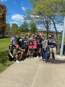 Group of men standing as a group while holding a plaque