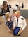 Soldier in uniform getting patches put on by his son and daughter. The Soldier's wife is standing behind the kids.